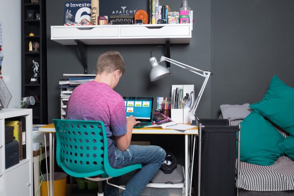 Student completing homework on desk in bedroom