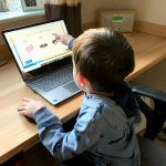 A young child using an interactive spelling game on Classroom Secrets Kids