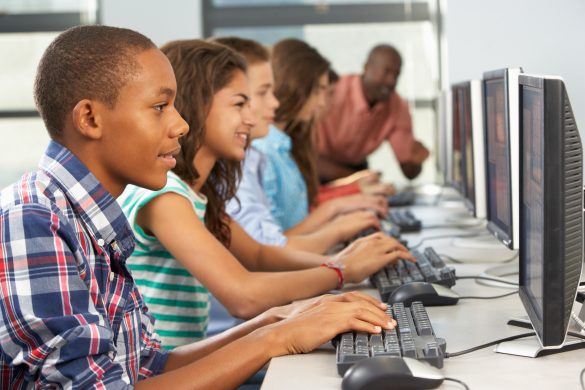 Row of students sitting at desktop computers.